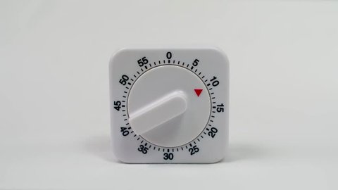 Egg timer / kitchen alarm clock in white plastic on white background ticking down from 10min. - timelapse