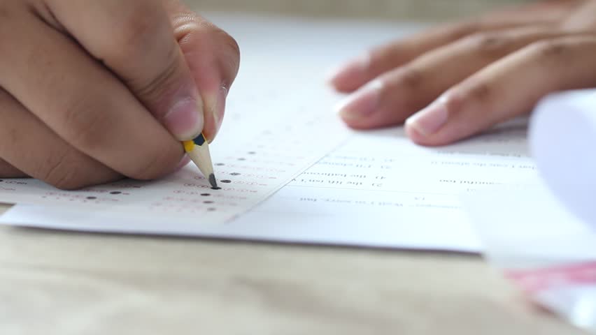 Education test concept : Man Hands high school, university student holding pencil for testing exams writing answer sheet and exercise for taking in exam paper on wood table at classroom with uniform Royalty-Free Stock Footage #1010944517