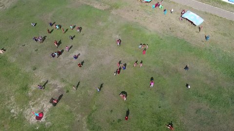 Aerial drone shot of Mongolian wrestlers during the naadam festival. From medium to high altitude on horizon, discovering a stadium.