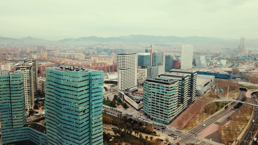 Modern urban landscape of Barcelona in coastal zone with view of mountains