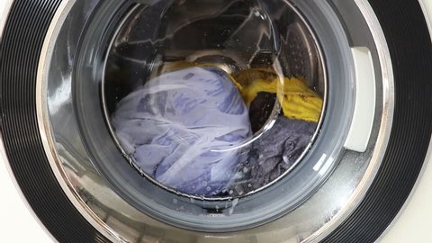 Washing machine full of dirty clothes.