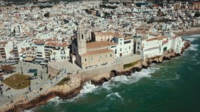 Aerial view of Sitges small town with church on Mediterranean coastline, Spain