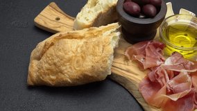 sliced prosciutto, cheese and salami sausage on a wooden board
