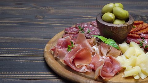 sliced prosciutto, cheese and salami sausage on a wooden board