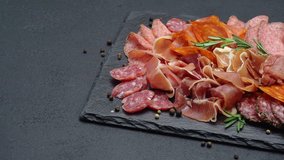 meat plate - sliced prosciutto and salami sausage on stone serving board