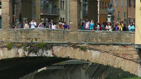 Florence, Tuscany, Italy - July 22 2017 - zoom out from close up of tourists on the Ponte Vecchio bridge over the river Arno, Florence Italy,