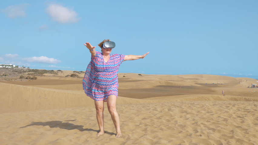 Professional video of senior woman wearing virtual googles on desert in 4k slow motion 
 - Powered by Shutterstock - Get 15% off with code: PIKWIZARD15