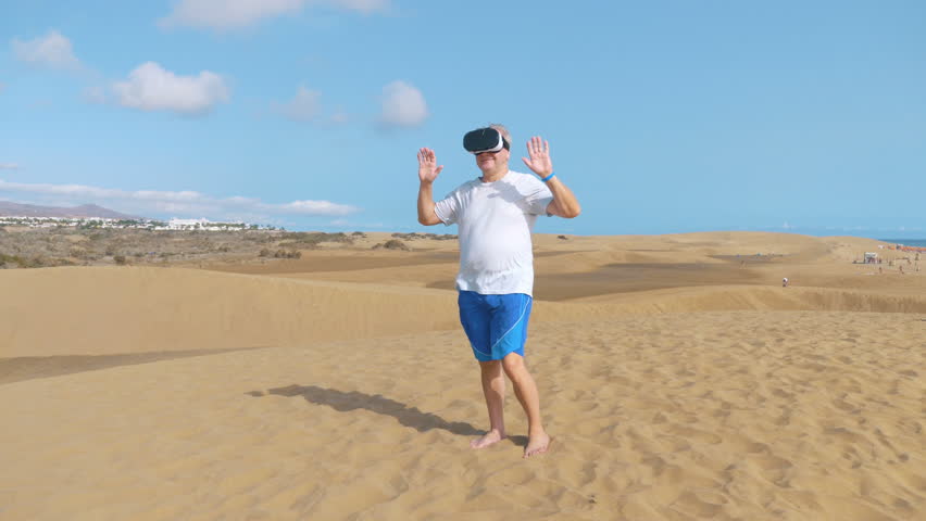 Professional video of senior man  wearing virtual googles on desert in 4k slow motion  - Powered by Shutterstock - Get 15% off with code: PIKWIZARD15