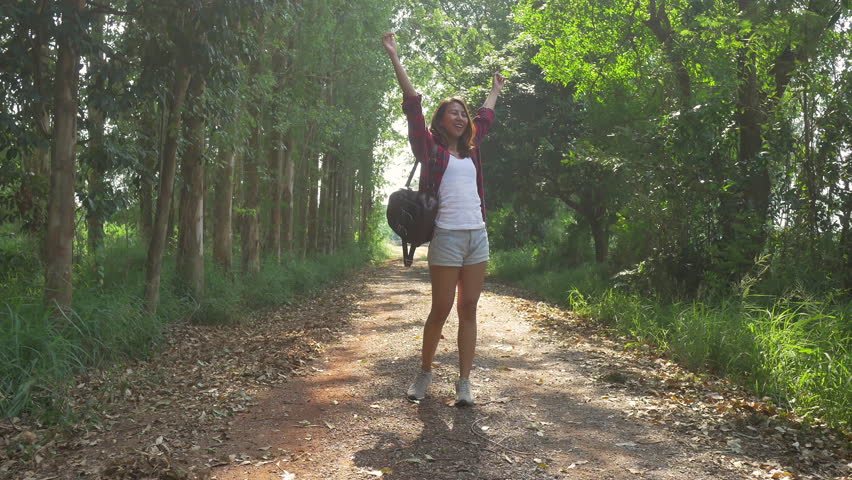 Happy young Asian woman traveler with backpack walking in forest. Hiker Asian  woman with backpack walking on path in summer forest. Adventure backpacker  travel people concept. - Free HD Video Clips 