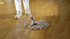 cleaning concept, housekeeping: video of unrecognizable cleaning woman cleaning a wooden floor