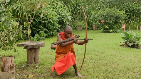 ARUSHA, TANZANIA - OCTOBER 2016: A young Meru person focusing an object with traditional weapons(a bow and an arrow) October 2016 in Arusha, Tanzania.