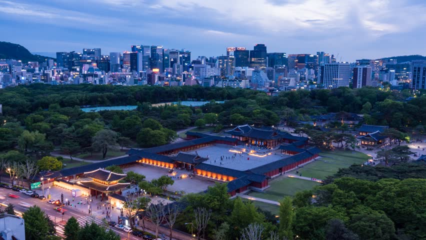 Time lapse of Changgyeonggung Palace and Seoul skyline at night.