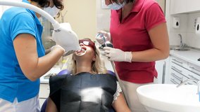 4k video of dental nurse helping dentist treating patient's teeth