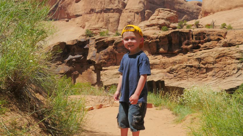 Young boy walking, around on the hiking trail.