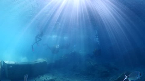 scuba divers learning diving underwater sun beams sun rays fish around try dive for beginners 