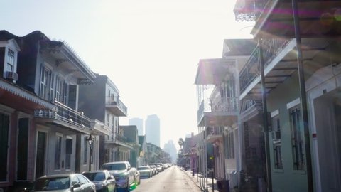 Establishing shot of a street with victorian houses in New Orleans, Louisiana. The wrought iron balconies weathered the damage from hurricane Katrina and the yearly worsening of hurricane season.