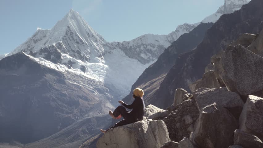 Woman massaging her feet on the top of the park Huascaran and lake Paron, Huaraz. Slow motion