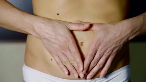 woman has a fat stomach. Weight loss and weight loss concept. The girl pulls the skin on her stomach, which is stretched and flabby after weight loss or giving birth to a child