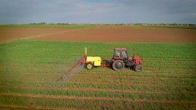 The tractor pulls a machine for spraying onion. 4K aerial stock footage clip.