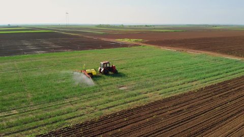 The tractor pulls a machine for spraying onion. 4K aerial stock footage clip.