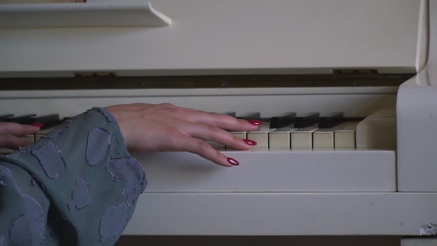A young maiden hand gently touches the keys