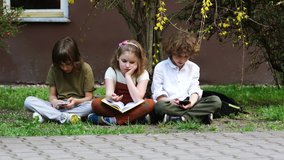 Students communicate in social networks using smartphones, the girl wants to show them the book they read. the boys are not interested. Leisure of schoolchildren, active leisure. Gambling addiction