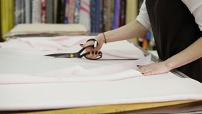 A fabric store worker, cuts off the necessary piece of fabric for the client. The girl folded the cloth on the table. Close up - Powered by Shutterstock - Get 15% off with code: PIKWIZARD15