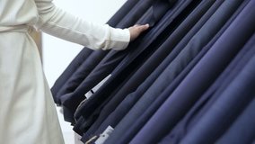 Aim shooting of female customer goes through different types of tissue by hand. From dark colour to light one. Chose one and take a roll, opened it. Textile store - Powered by Shutterstock - Get 15% off with code: PIKWIZARD15