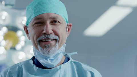 Portrait of the Professional Surgeon Taking off Surgical Mask after Successful Operation. In the Background Modern Hospital Operating Room. Shot on RED EPIC-W 8K Helium Cinema Camera.