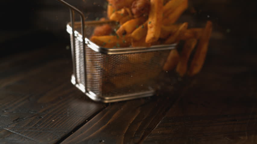 Camera follows french fries falling on wooden table. Shot with high speed camera, phantom flex 4K. Slow Motion. Royalty-Free Stock Footage #1011040607