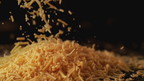 Camera follows shredded cheddar cheese. Shot with high speed camera, phantom flex 4K. Slow Motion.