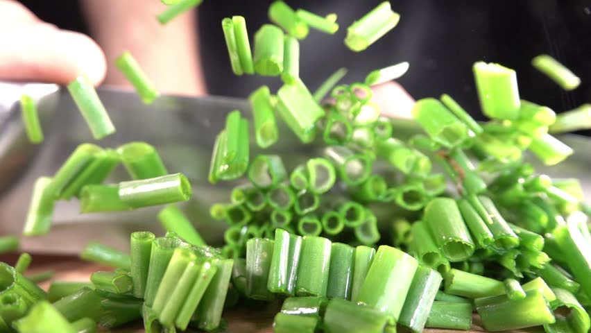 Cutting fresh green onions on a cutting board. | Shutterstock HD Video #1011063659
