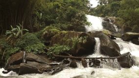 Whitewater cascades over a natural waterfall and around enormous boulders at this natural waterfall in a tropical wilderness area in Thailand. Ultra HD 4k video