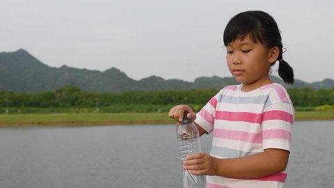 Slow motion: Girl drinking water from bottle on outdoor, Thirsty and  Healthy concept