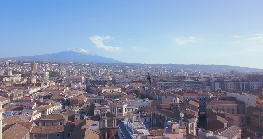 Beautiful aerial view of the Catania city with main Cathedral and Etna volcano on the background. Amazing old town view.