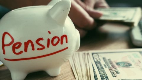Pension on a piggy bank and counting money. Retirement savings.