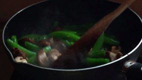Slow motion clip: Fried vegetables, sugar snap pea, mushrooms and shrimps in hot pan. Healthy food concept.