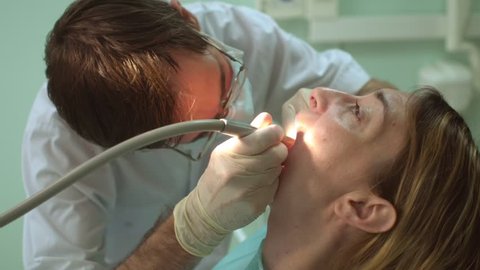 Beautiful happy woman at dental clinic Dentist examining teeth