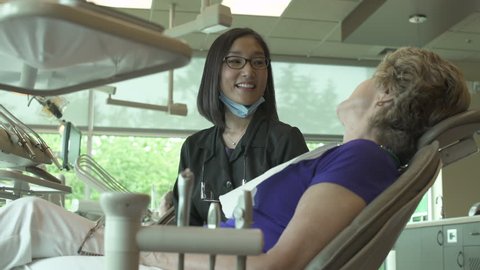 Medium shot of a dentist talking to a woman