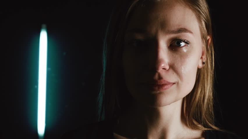 A woman is crying in the dark. Tears of a beautiful girl. 4k | Shutterstock HD Video #1011093383