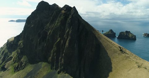 Aerial: Epic mountains in the Atlantic ocean. Stunning cliffs. Sunny day. Iceland.