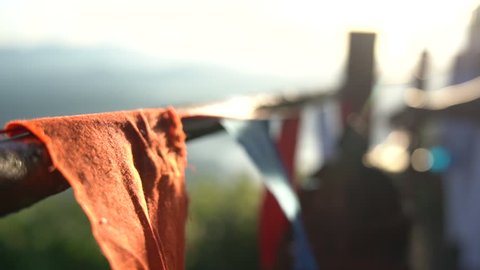 Buddhist prayer flags swaying in the wind at sunrise in a temple in Sri Lanka.  Close up Slow Motion Footage. Shallow depth of field,