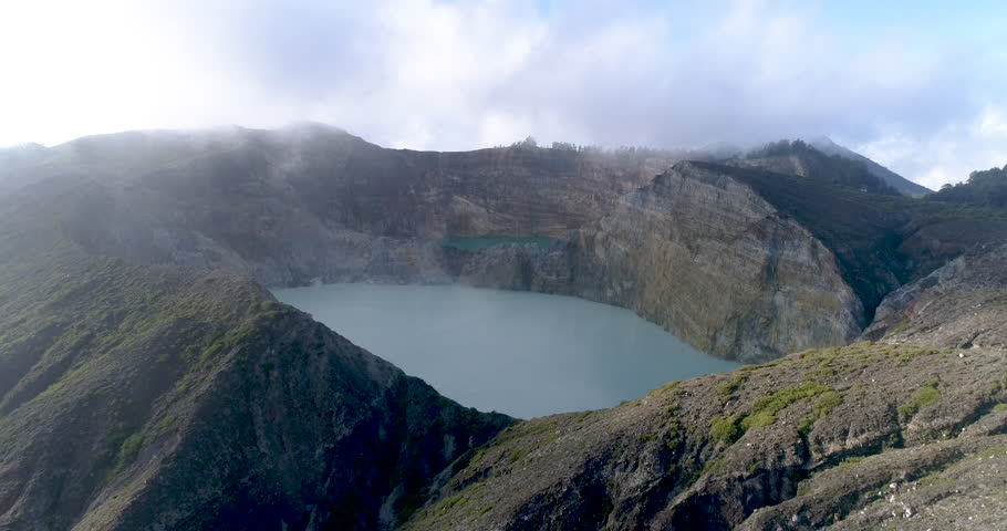 Kelimutu tri coloured volcano crater covered with mist an aerial view early morning, Indonesia
