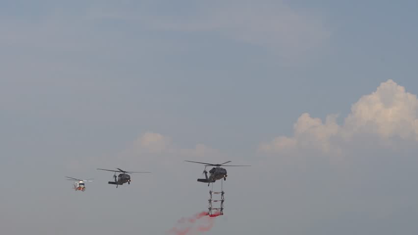 Military helicopter flying close with soldiers inside a way. Way Day make presentations of combat equipment and weapons in the military Black sea port