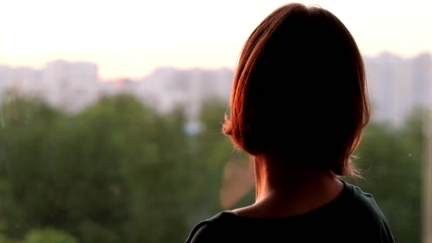 Woman standing at the window and looking at sunset | Shutterstock HD Video #1011124673