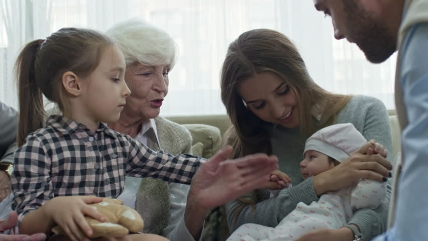 PAN of grandmother, little girl and young parents playing and soothing fussy baby girl | Shutterstock HD Video #1011130271