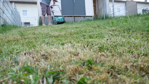 Man cutting lawn with grass mower