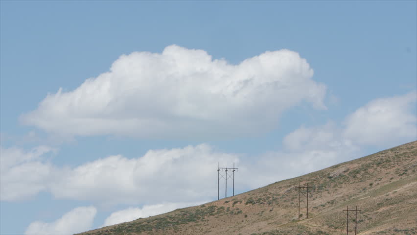 Clouds Drift Above a Large Hill on a Sunny Day