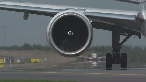 huge airplane jet engine close up view moving forward heat haze distant airplane lining up behind