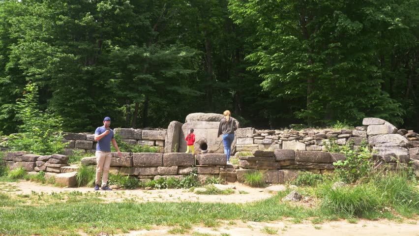 Dolmen in the forest. 4k, slow motion. tourists explore the ancient dolmens